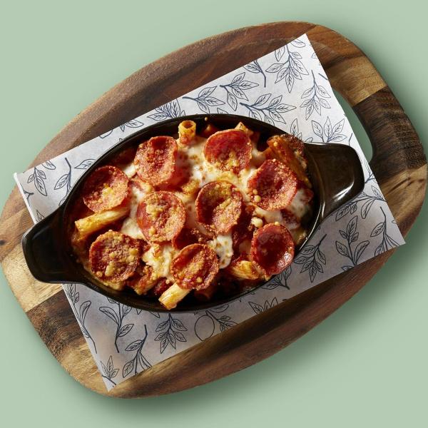 Cast iron dish of pepperoni-topped pasta